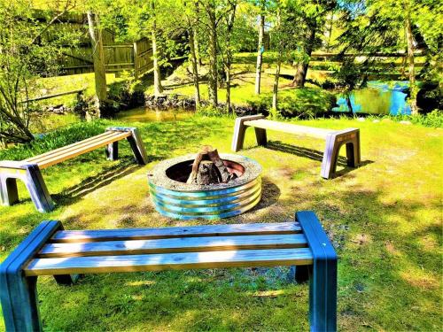 a park with two benches and a fountain in the grass at 3 Cottage Exclusive Retreat-Hot Tubs-Walk to Beach in Traverse City