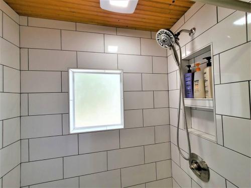 a bathroom with a shower with a window at 3 Cottage Exclusive Retreat-Hot Tubs-Walk to Beach in Traverse City