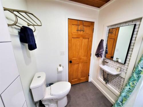a bathroom with a white toilet and a sink at 3 Cottage Exclusive Retreat-Hot Tubs-Walk to Beach in Traverse City