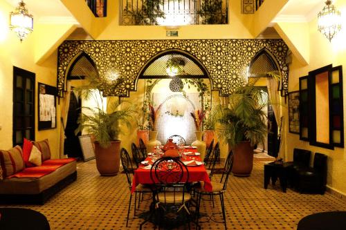 a dining room with a table and chairs in a room at Riad Dar La Rose in Marrakech
