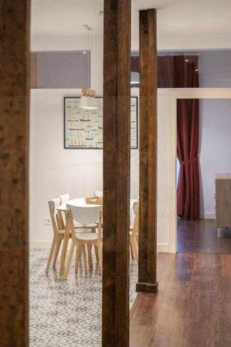 a dining room with a white table and chairs at Lavaderu Apartamento in Gijón
