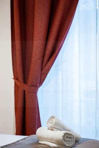 a towel sitting on a bed in front of a curtain at Lavaderu Apartamento in Gijón