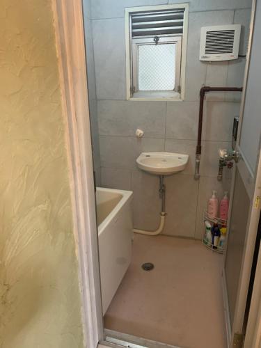 a small bathroom with a sink and a bath tub and a sink at 山下ホテル308 in Kurosakimachi