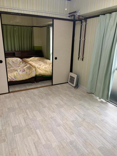 a bedroom with a bed and a television in it at 山下ホテル308 in Kurosakimachi