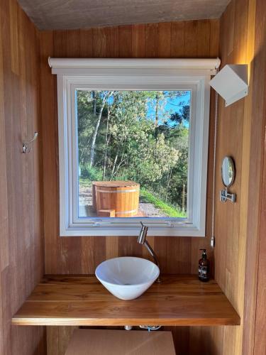 uma casa de banho com um lavatório e uma janela em Refúgio Casa de Pedra em Cambará