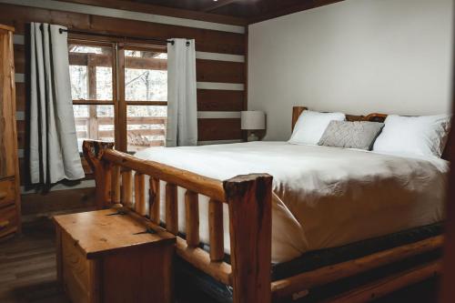 sypialnia z dużym łóżkiem i oknem w obiekcie Wolf Creek Cabin at 36 North - Hot Tub w mieście Purlear