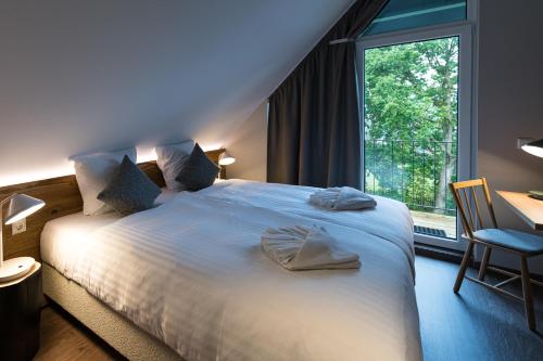 a bedroom with a large bed with towels on it at Harz-Urlaubs-Alm Hotel & Ferienhäuser in Clausthal-Zellerfeld