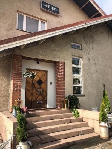 eine Haustür eines Hauses mit Treppen und Blumen in der Unterkunft Haus Anna in Rauma