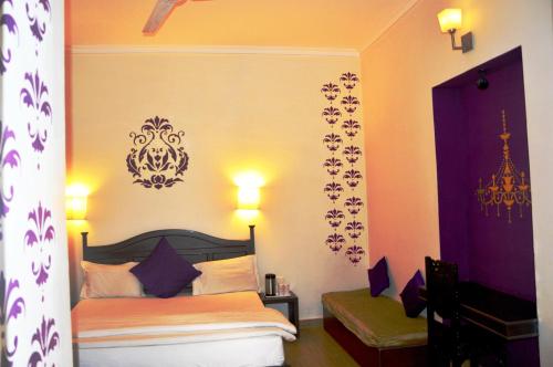a bedroom with a bed with purple walls at La Casa in Haridwār