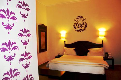a bedroom with a bed with a purple and white wall at La Casa in Haridwār