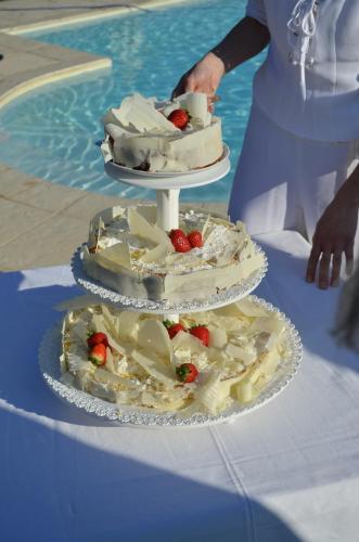 a three tiered cake on a table next to a pool at Il Rifugio del Poeta in San Biagio di Callalta