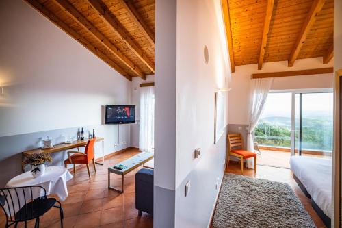 a room with a bed and a living room with a table at VilaFoia in Monchique