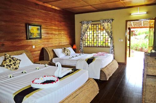 a hotel room with two beds and a window at Atmaland Resort in Kep