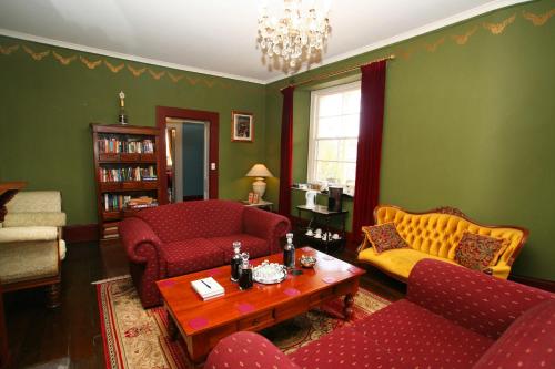 a living room with red furniture and green walls at The Lodge on Elizabeth Boutique Hotel in Hobart