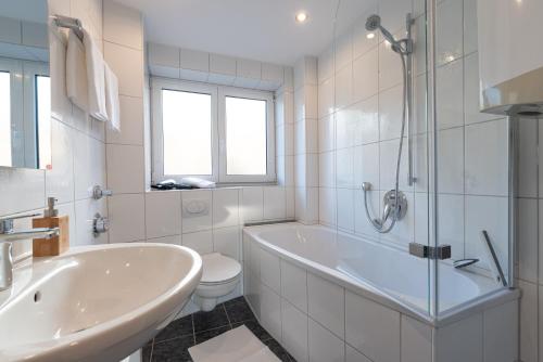a bathroom with a tub and a toilet and a sink at SMS-Homes I AUSZEIT im BERGBLICKparadies in Sonthofen
