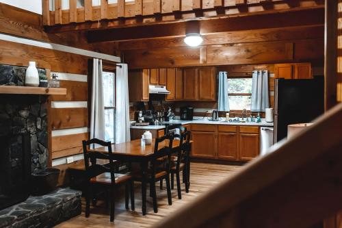 een keuken en eetkamer met een tafel en stoelen bij Serenity Ridge Cabin at 36 North - Hot Tub in Purlear