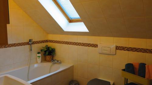 een badkamer met een bad en een dakraam bij Ferienhaus Gute Laune in Lichtenhagen