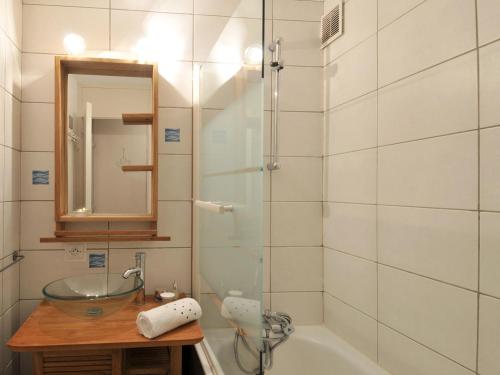 une salle de bain avec un lavabo, une baignoire et un miroir dans l'établissement Appartement cosy avec accès pistes, casier à skis et parking souterrain - FR-1-181-2036, à La Plagne Tarentaise