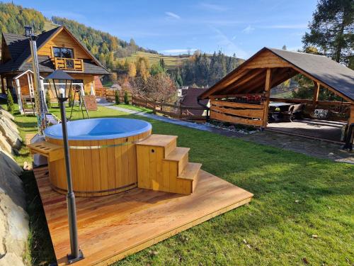 una bañera de hidromasaje en una terraza junto a una casa en Domek Góralski nad Czorsztynem - Kluszkowce en Kluszkowce