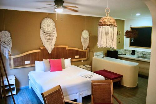 Un dormitorio con una cama y un escritorio. en Santuario Playa, en Playa del Carmen