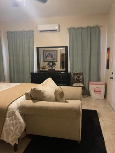 a bedroom with a bed and a chair and a mirror at Bella Vista Vacation in Montego Bay