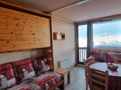 un salon avec un canapé et une table avec vue dans l'établissement Studio confortable au pied des pistes, balcon, animaux admis - FR-1-181-2562, à Aime La Plagne
