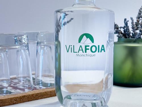 a bottle of water on a table with glasses at VilaFoia in Monchique