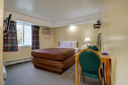 a hotel room with a bed and a table and chairs at Classic Inn in Saco