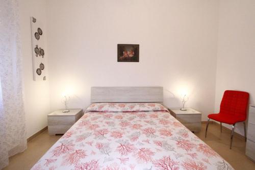 a bedroom with a bed and a red chair at Villa Lata in Marina San Gregorio