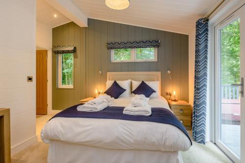 a bedroom with a large bed with two towels on it at Woolverstone Marina and Lodge Park in Ipswich