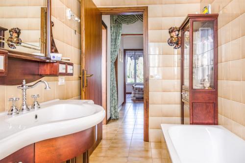 La salle de bains est pourvue d'un lavabo et d'une baignoire. dans l'établissement Villa Carini with 3000 mq garden & heated pool, à Castelnuovo del Garda