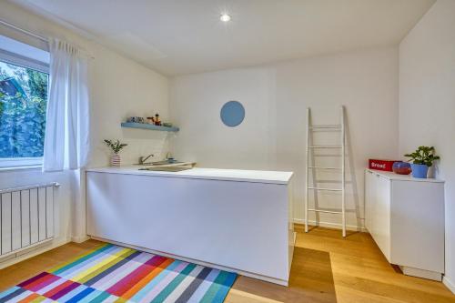 um quarto com um balcão branco e um tapete colorido em Centrally located apartment with parking space em Caldaro