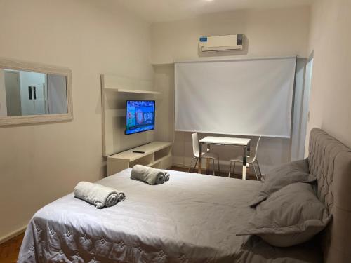 1 dormitorio con cama y pantalla de proyección en Depto ubicado en Recoleta en Buenos Aires