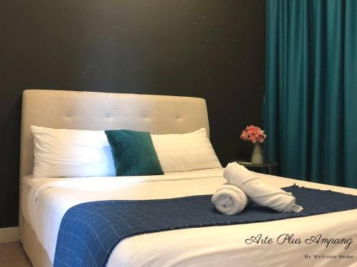 a bed with a blue and white blanket and pillows at Arte Plus Jalan Ampang KLCC in Kuala Lumpur