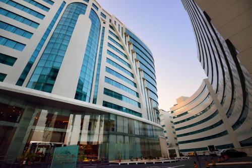 a large building with glass windows in a city at Holiday Villa Hotel & Residence City Centre Doha in Doha