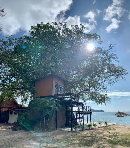 a tree house on a rock next to the water at Ocean Vibes in Thongsala