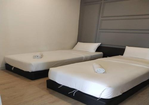 two beds in a small room with white sheets at Arte Plus Jalan Ampang KLCC in Kuala Lumpur