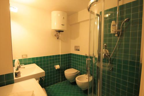 a green tiled bathroom with a toilet and a shower at Fabrizi79 in Pescara