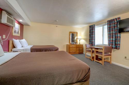 um quarto de hotel com duas camas e uma secretária em Classic Inn em Saco