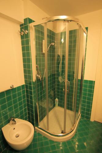 a green tiled bathroom with a shower and a sink at Fabrizi79 in Pescara