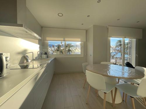 a kitchen and dining room with a table and chairs at Apartaments Voramar Roses in Roses