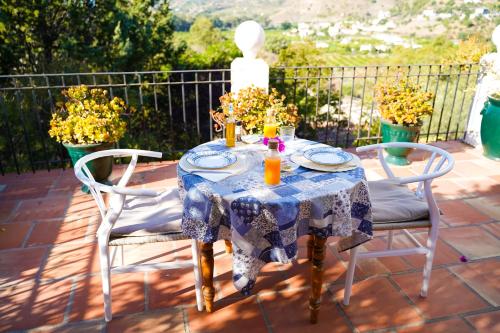 een tafel met een blauw en wit tafelkleed op een patio bij La Barranca de la Barca in Alora