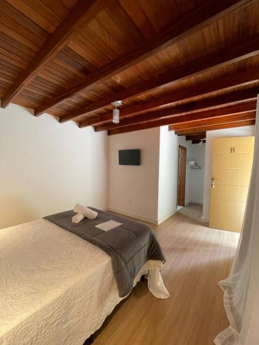 a bedroom with a bed and a wooden ceiling at Pousada Cozy House in Itaipava