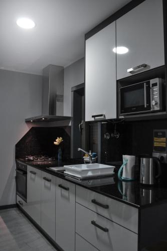 a black and white kitchen with a sink and a microwave at Anevan in Vidago