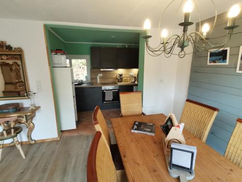 eine Küche und ein Esszimmer mit einem Holztisch und Stühlen in der Unterkunft adBs Ferienhaus in Winterberg