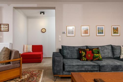 a living room with a couch and a red chair at Kyra’s House in Neraïdochóri