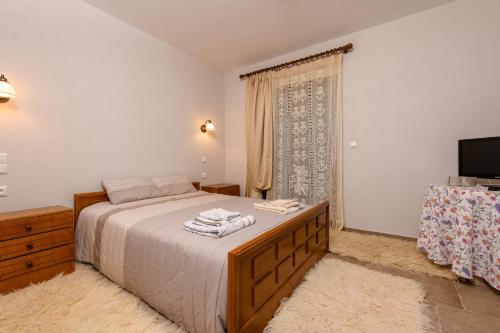 a bedroom with a bed and a tv and a window at Kyra’s House in Neraïdochóri