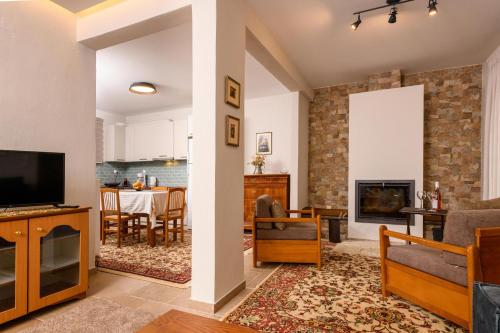 a living room with a tv and a fireplace at Kyra’s House in Neraïdochóri