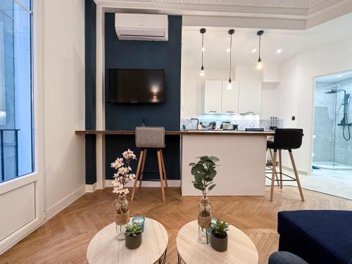 un salon avec deux tables et une cuisine dans l'établissement CLEMENCEAU - Appartement Central, Calme, Cosy, Moderne, à Nice