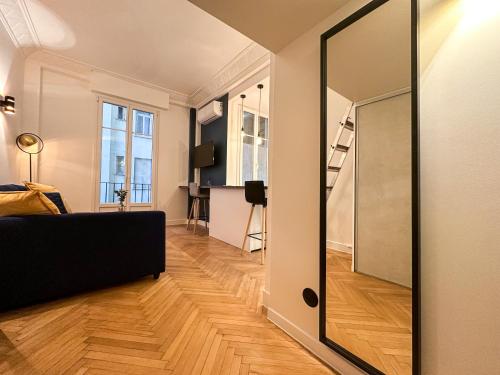 - un salon avec un canapé noir et un miroir dans l'établissement CLEMENCEAU - Appartement Central, Calme, Cosy, Moderne, à Nice